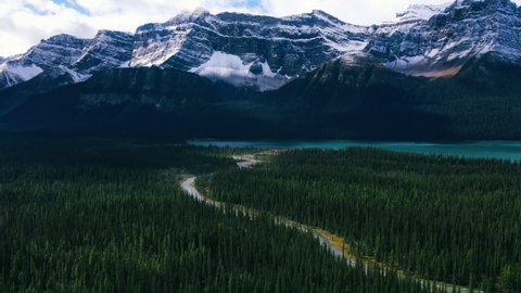 Ariel View of Road in Mountains and Green Pine Forest in Banff National Park. Mountain lake with turquoise water. Scenic view in Rocky Mountains in Canada. Road trip.