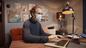 Mixed race american freelancer man in medical protective mask communicating via laptop, working remotely being isolated during coronavirus lockdown. Professional teacher giving online language class.