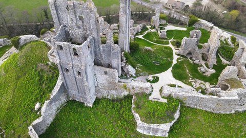 Aerial top-down ascendent over Corfe Castle ruins in County Dorset, England