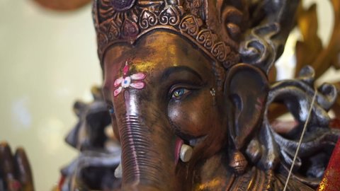 ganpati statue of Indian god dark stone slow motion face close up