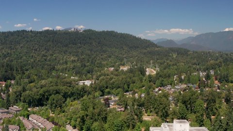 Drone Flight Towards Electrical Substation In Burnaby, BC, Canada With Simon Fraser University On Burnaby Mountain In Background. wide aerial