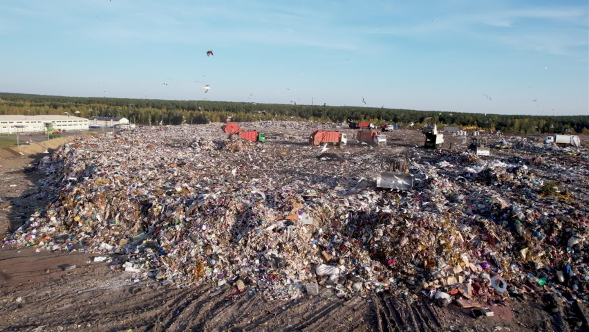 Garbage dump with waste plastic, polyethylene and food waste. Trash disposal for recycling and re-use. Bulldozer at landfill working on rubbish disposal. Dozer on a industrial landfill.  Royalty-Free Stock Footage #1081714133