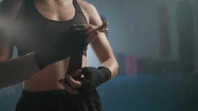 Woman fighter wraps her hands with boxing bandages, kickboxing training day in a gym, female fighter is preparing for battle, 4k slow motion. - Powered by Shutterstock - Get 15% off with code: PIKWIZARD15