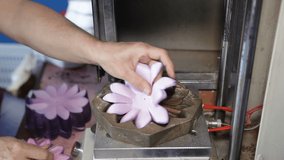 A woman works at a machine for the production of artificial flowers. Making synthetic flowers from fabric.Video contains sound.
