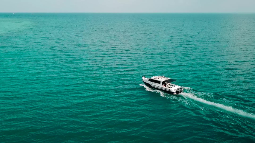 Drones see blue clear water boat. Top view of a white speed boat sailing into the blue sea. Big fast boat moving towards the island | Shutterstock HD Video #1081715561