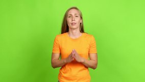 Young blonde girl pleading over isolated background. Green screen chroma key