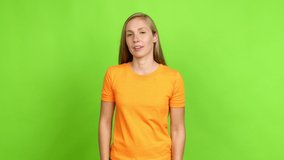 Young blonde girl looking front over isolated background. Green screen chroma key