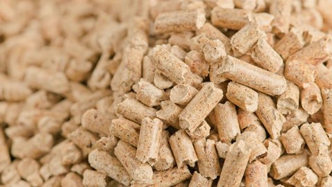 looped close-up rotation of compacted wooden sawdust pellets - natural cat litter filler or organic fuel