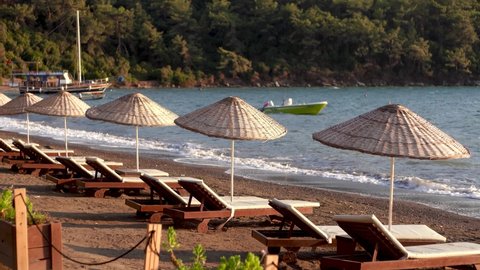 Many empty beach chairs and umbrellas standing on sandy beach of Turkey, Marmaris