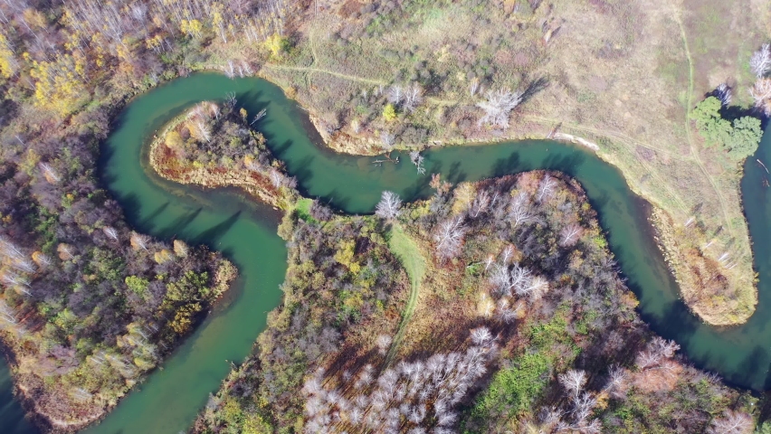 Aerial video of meanders of the Koen river. Beautiful autumn landscape from above. Novosibirsk, Siberia, Russia. Camera moves sideways.