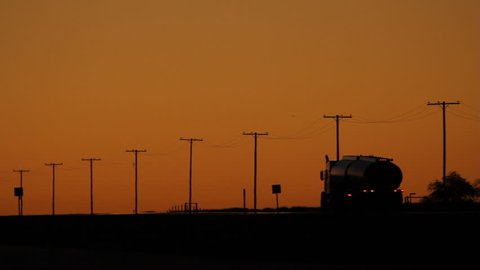Trucks at dusk travelling on TransCanada Highway 1. Saskatchewan, Canada. 
