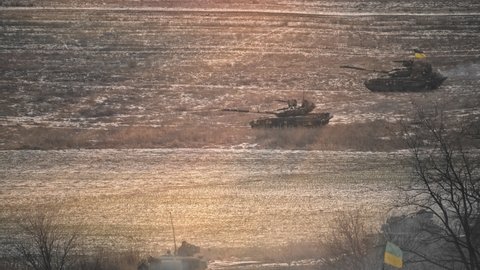 Mass of main battle tank T64 driving through winter plains. Powerful armed military vehicles going for training. Heavy armored army machines ready for defense. Side view footage.