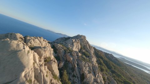 FPV video, mountain surfing, flying at high speed over a granite mountain during a sunny day. Caprera Island, La Maddalena archipelago, Sardinia, Italy.