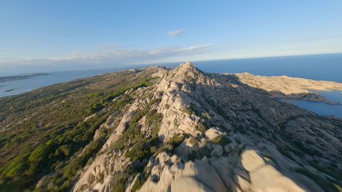 FPV video, mountain surfing, flying at high speed over a granite mountain during a sunny day. Caprera Island, La Maddalena archipelago, Sardinia, Italy.
