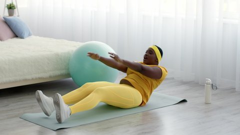 Overweight Black Woman Doing Abs Crunches Exercise While Training At Home, African American Plus Size Female In Sportswear Lying On Fitness Mat, Working Out Abdominal Muscles, Slow Motion Footage