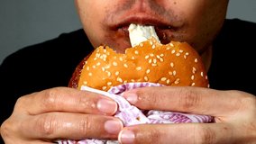 Japanese man eating teriyaki burger