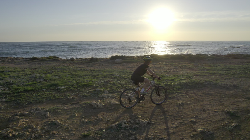Woman Biking at the Seaside, Aerial at Sunset