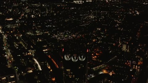 Top of Strata high rise building with integrated three wind turbines. Sustainable source of energy. Aerial night view of city. London, UK