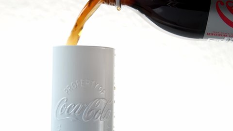 Frankfurt, Germany, October 2021: close-up of white glass from the Coca-Cola Company, brand name is highlighted, plastic soda bottle with gray label, low sugar, soft drinks concept