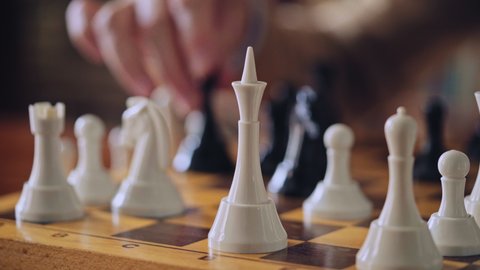 Grandmaster's hand moving chess piece, calling out checkmate to opponent, hobby