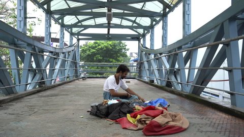 Homeless man living on the skywalk, Mumbai, India, Circa 2021
