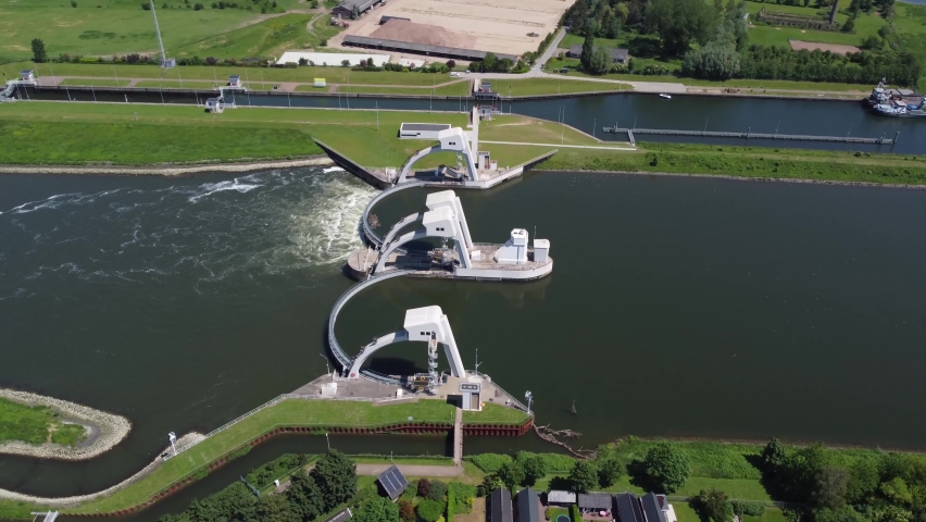 High altitude aerial view of modern water channel controller controlled at both sides by a gate or lock these gates commonly control levels and flow rates in rivers and canals 4k drone footage Royalty-Free Stock Footage #1081741883