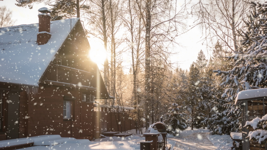 Bright sunny landscape with snow falling snow and a small house in the forest, cinemagraph, video loop Royalty-Free Stock Footage #1081744607