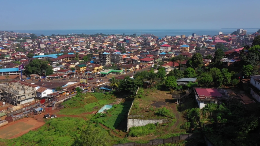 Aerial Freetown city congested building traffic part 1. West Africa suffers extreme poverty and hunger. Congested crowded homes and businesses. Tropical climate. 