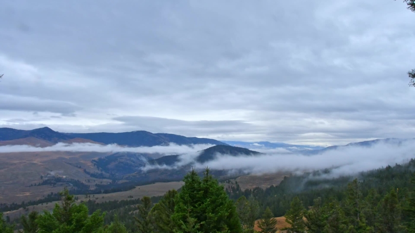 Overcast day in Yellowstone. Timelapse of stratus clouds moving left to right with fog forming and moving among the mountains. Camera fixed, from Grand Loop Road between Mammoth and Roosevelt.