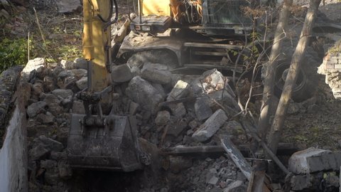 Demolition of ancient historical buildings, excavator breaks down an old vintage house. construction of new buildings on the site of abandoned housing concept. Urban Renewal 4k High quality video