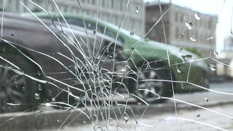The car through the cracks in the glass. The concept of the dangers of driving on the streets and stressful situations on the roads. Accidents and catastrophes on the highway