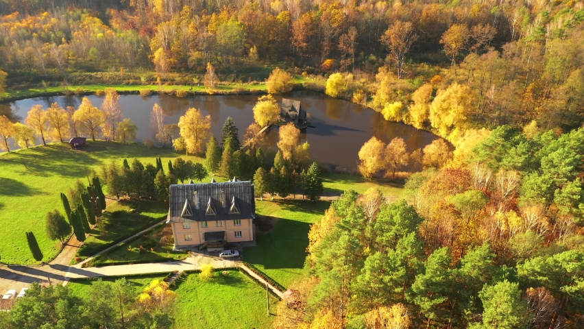 Wooden old fisherman house on small island in the autumn park. Bird
