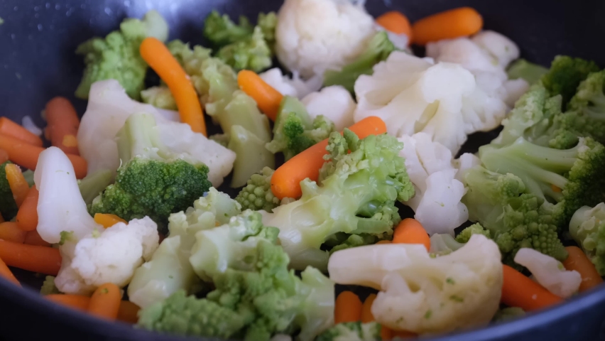 Frozen vegetables being cooked in a frying pan. Royalty-Free Stock Footage #1081753142