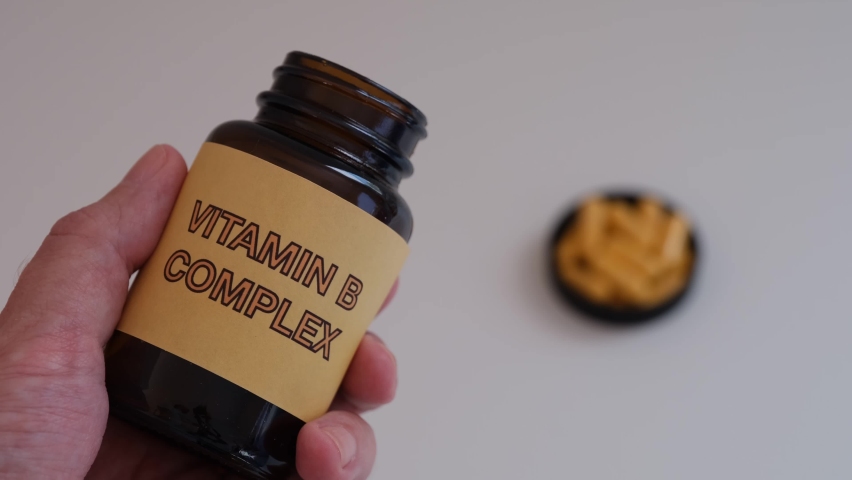 A man holding a bottle of Vitamin B Complex in his hand. Close up. Royalty-Free Stock Footage #1081753148