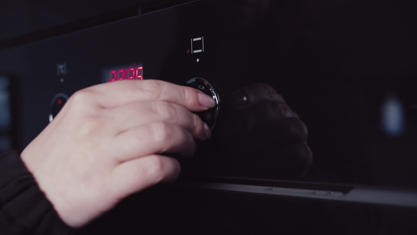 cinematic, man turns on the oven for baking, cooking dinner at home in the evening, mooving camera