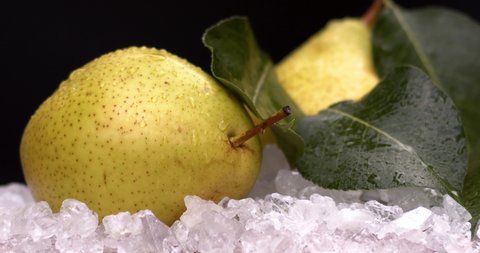 Yellow fresh pear cold ice with fresh and yummy pears, natural and organic fruits in black background. Filmed high speed cinema camera, slow motion footage, downscale, 4K.