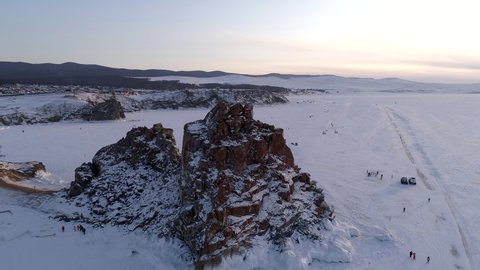 Aerial shot of Shamanka rock and Cape Burkhan on Olkhon. Beautiful view on frozen Baikal. Panoramic winter landscape. Popular touristic destination