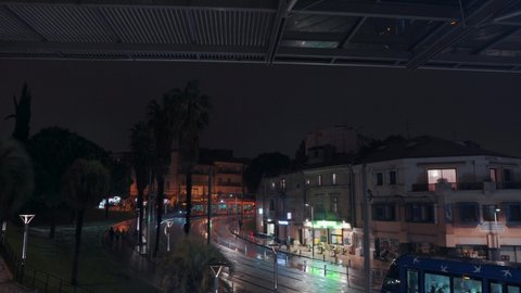 A yellow tram is coming and a blue tram is leaving on a rainy night, Montpellier - France