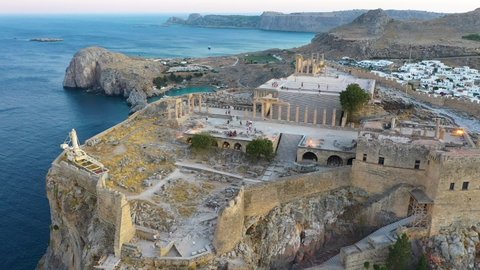 Aerial drone shot above ruins of Acropolis of Lindos, Rhodes, Dodecanese Islands, Greek Islands, Ancient architecture of Rhodes, Greece. Steep cliff overlooking the sea, framed by fortress walls.