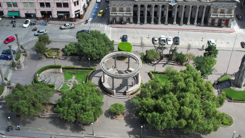 Parque Centro America Centro Historico Quetzaltenango, Xela Guatemala. Drone footage of neoclassical round structure with elegant columns in urban colonial highlands Guatemalan historic district park. Royalty-Free Stock Footage #1081763759