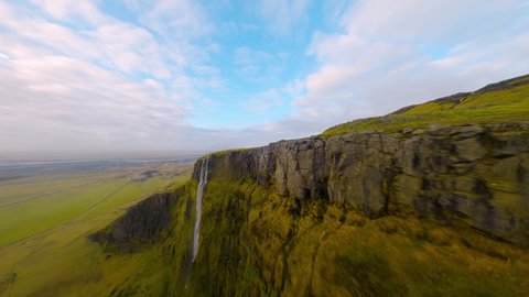 FPV drone shot diving down a waterfall, in partly sunny Esjan mountains, Iceland : vidéo de stock