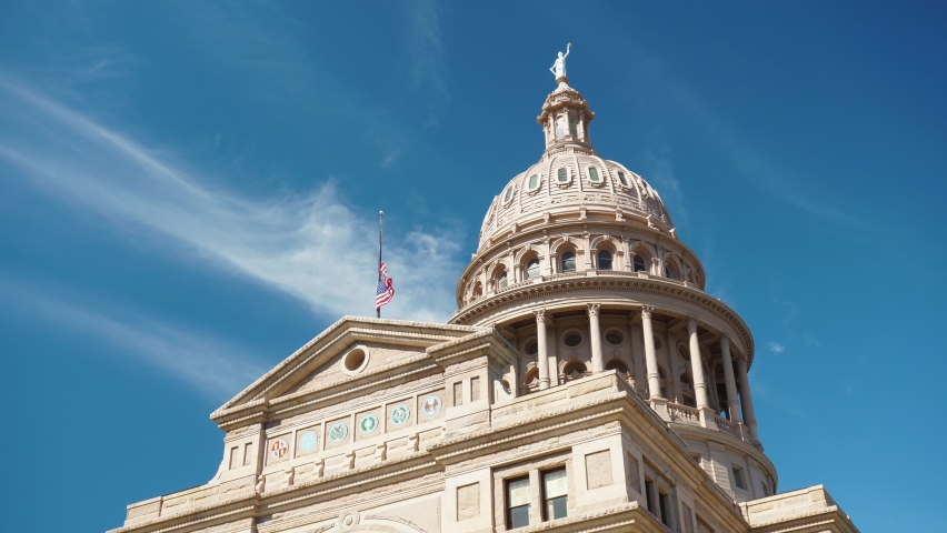 Texas Capitol Building in Downtown Austin TX with US American Flag flying at half mast (4k)
