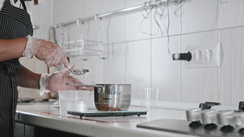 Woman chef in white kitchen making sugar syrup