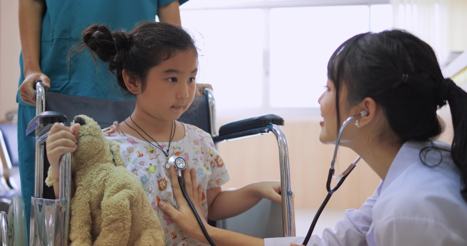 Asian woman doctor checkup little girl sit on wheelchair with stethoscope in hospital , healthcare service concept | Shutterstock HD Video #1081771406