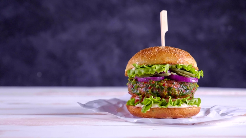 Vegan burger on a white table and with a dark blue background. Vegetable meat. Ready to eat.  | Shutterstock HD Video #1081773431