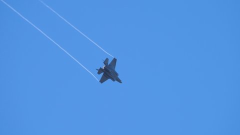 Rivolto, Italy SEPTEMBER, 17, 2021 Military jet plane very fast fly in loop with chemtrails tail and blue sky background. Lockheed Martin F-35B Lightning II Stealth Fighter Jet of Italian Air Force