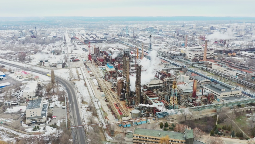 Massive nitrogen chemicals facility complex throwing smoke into sky. Obsolete soviet factory near road in the middle of Eastern European cityscape. Aerial view 4k UHD footage.   Royalty-Free Stock Footage #1081777751