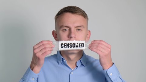 A man gluing his mouth with tape with the words Censorship