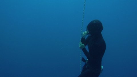 free diver girl trying to blast ears. Freediving is a sport when a person dives into sea water while holding his breath. An extreme type of underwater diving to a depth without professional equipment.
