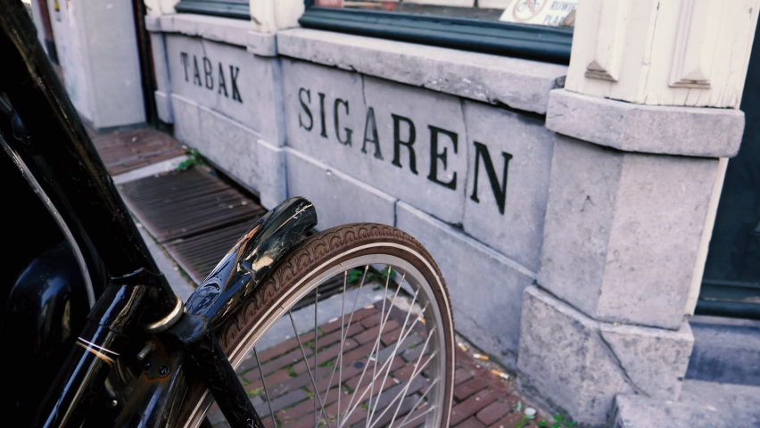 Old vintage inscription Tabak Sigaren on the old facade in Leiden, The netherlands of ancient store selling tobacco and cuban cigars - slow focusing to parked nearby bike